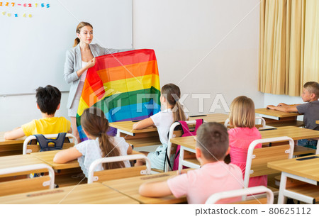 Positive female teacher standing with lgbt flag 80625112
