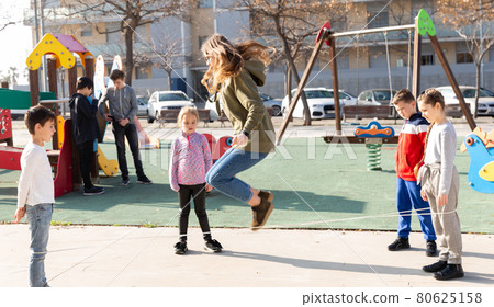 Children skipping on elastic jump rope Children skipping on elastic jump rope 80625158