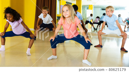 Portrait of smiling children practicing sport dance in modern dance hall Portrait of smiling children practicing sport dance in modern dance hall 80625179