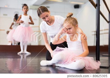 Ballet teacher comforting tired little ballerina 80625305