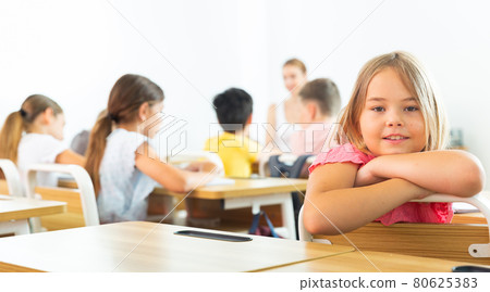 Schoolgirl sitting in classroom 80625383