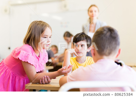 Preteen schoolchilds working in groups at lesson 80625384