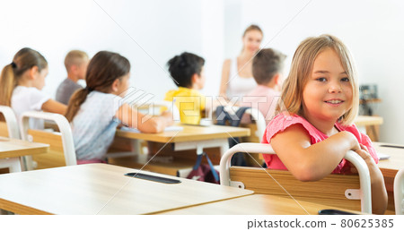 Schoolgirl sitting in classroom 80625385