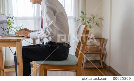 A man with a bad posture. A businessman who works at home. A man with a bad posture. A businessman who works at home. 80625809