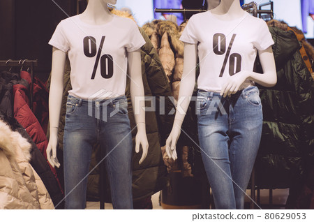 Shopping, sale and discounts at clothing stores. Percent sign on a white t-shirt in a clothing store Shopping, sale and discounts at clothing stores. Percent sign on a white t-shirt in a clothing store 80629053
