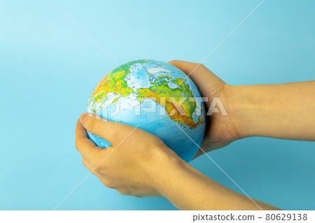 Preservation and protection of nature and the Earth. Earth globe in female hands on a blue background. Ecology and nature conservation concept 80629138