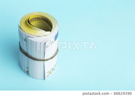 Money and income concept. Euro cash banknotes on a blue background. Saving and spending money Money and income concept. Euro cash banknotes on a blue background. Saving and spending money 80629390