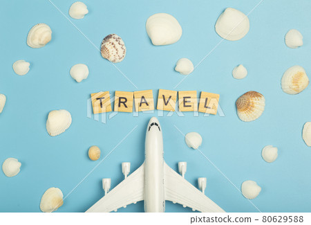 Travel summer background. Airplane and seashells on a colored blue background. Tourist vacation, relaxation and summer concept. 80629588