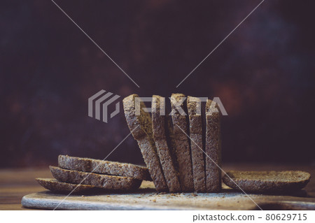 Homemade gluten free bread. Rye bread in bran and cereals on a wooden board on a background of the kitchen. Gluten Free Baking & Food Homemade gluten free bread. Rye bread in bran and cereals on a wooden board on a background of the kitchen. Gluten Free Baking & Food 80629715