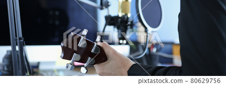 Woman hold ukulele against gold modern professional microphone 80629756