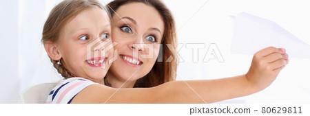 Blond smiling little girl make paper plane 80629811