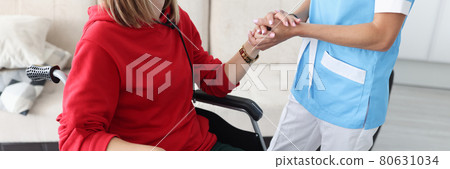 Therapist holding hand of disabled woman in protective medical mask closeup 80631034
