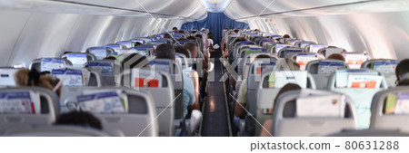 Passengers sitting in seats of plane back view 80631288