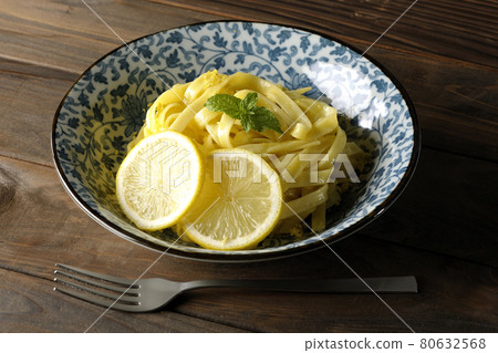 Lemon cream pasta and fork with lemon and spearmint cut into slices 80632568