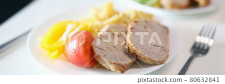Pieces of fried meat and vegetables lying on white plate closeup Pieces of fried meat and vegetables lying on white plate closeup 80632841