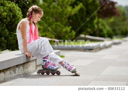 cute little girl on roller skates at park. 80633112