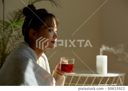 Young woman relaxing at home with a cup of fruit tea 80633922