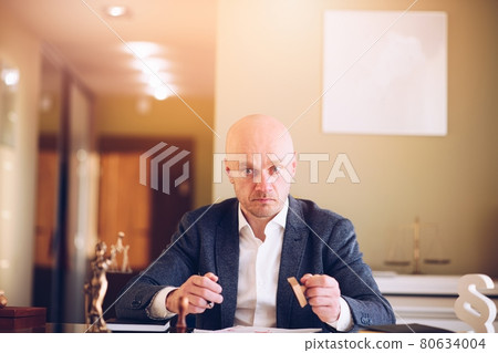 Lawyer or attorney working in the office. He prepares and signs documents for clients. Lawyer or attorney working in the office. He prepares and signs documents for clients. 80634004