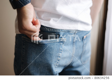 Back view of man taking wallet from back pocket Back view of man taking wallet from back pocket 80634256