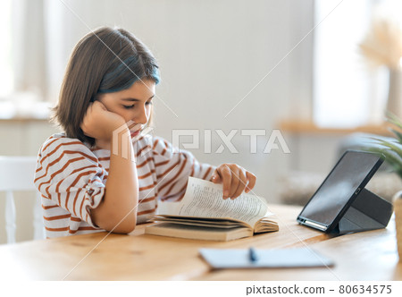 Girl doing homework or online education. 80634575