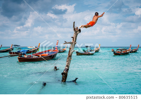 Asian boy jumping into the sea at Lipe island 80635515