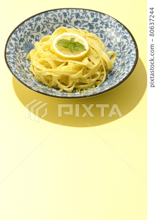 Photographed lemon cream pasta with lemon and spearmint cut into slices on a lemon-colored background Photographed lemon cream pasta with lemon and spearmint cut into slices on a lemon-colored background 80637244