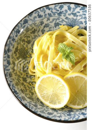 A bird's-eye view of lemon cream pasta with lemon and spearmint cut into slices on a white background A bird's-eye view of lemon cream pasta with lemon and spearmint cut into slices on a white background 80637586