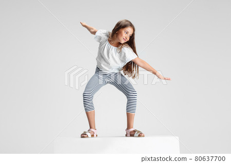 Caucasian preschool girl standing on big box isolated over white studio background. Copyspace. Childhood, education, emotions concept Caucasian preschool girl standing on big box isolated over white studio background. Copyspace. Childhood, education, emotions concept 80637700