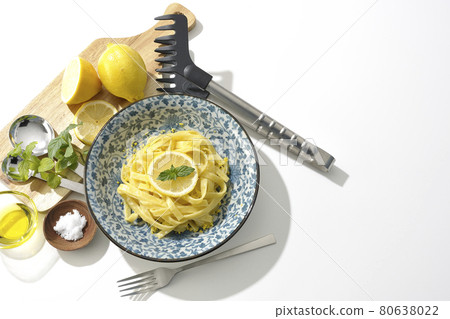 Lemon cream pasta with sliced lemon and spearmint, fork and olive oil, salt and more. Lemon cream pasta with sliced lemon and spearmint, fork and olive oil, salt and more. 80638022