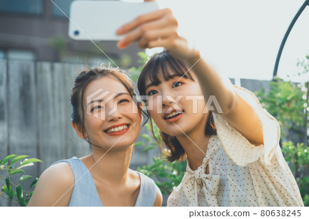 Girls taking selfies with friends 80638245