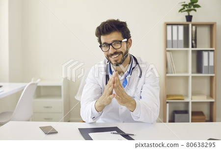 Webcam portrait of doctor sitting at desk during online consultation with patient 80638295