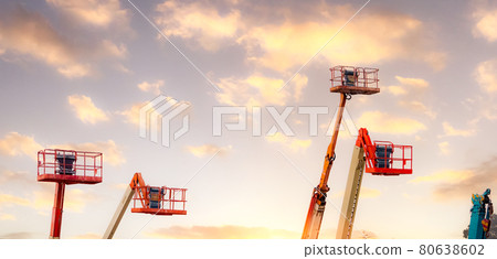 Articulated boom lift. Aerial platform lift. Telescopic boom lift against the sky. Mobile construction crane for rent and sale. Maintenance and repair hydraulic boom lift service. Crane dealership. 80638602