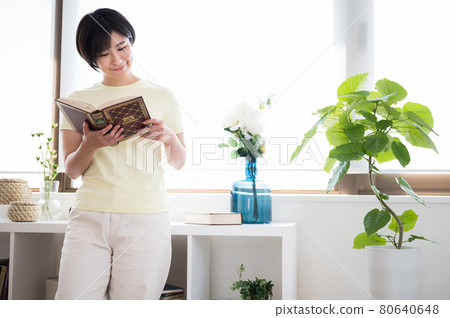 一個女人站在窗邊看書 一個女人站在窗邊看書 80640648