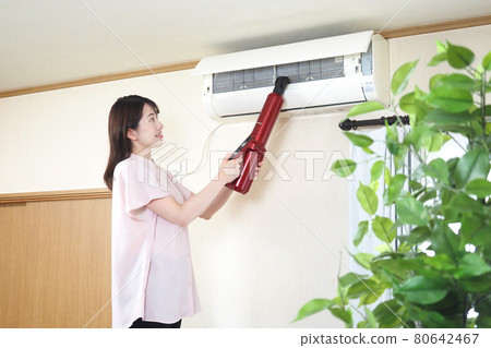 Housewife cleaning the air conditioner Housewife cleaning the air conditioner 80642467