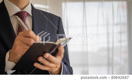 做筆記的商人。一個穿西裝的男人。 做筆記的商人。一個穿西裝的男人。 80642687