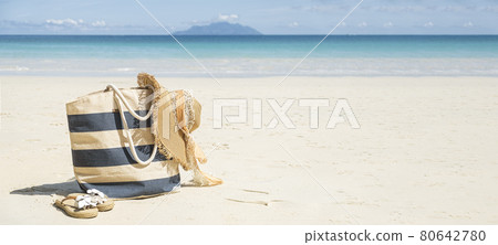 Stripy beach bag, straw hat and flip flops on tropical beach Stripy beach bag, straw hat and flip flops on tropical beach 80642780