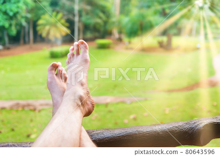 Bare feet of resting man on green lawn background Bare feet of resting man on green lawn background 80643596