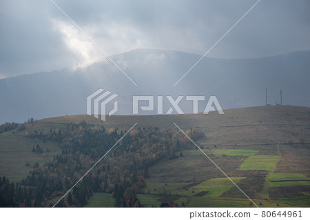 Morning foggy clouds in sunlight and autumn mountain countryside.  Ukraine, Carpathian Mountains, Borzhava Range, Transcarpathia. 80644961