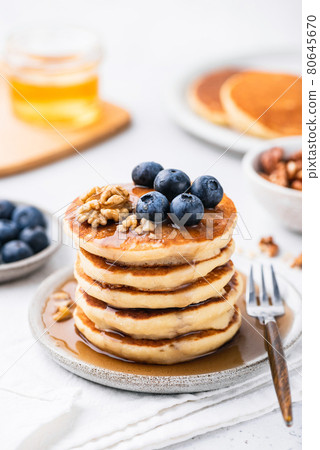 Sweet breakfast pancakes with blueberries, walnuts and honey 80645670