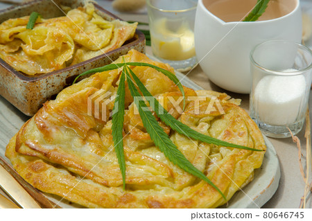 Close-up of Homemade sweet frying roti (Cannabis Pancake) with Cannabis served with Cannabis tea on ceramic plate. Close-up of Homemade sweet frying roti (Cannabis Pancake) with Cannabis served with Cannabis tea on ceramic plate. 80646745