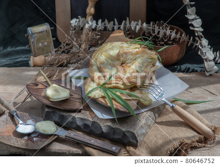 Homemade sweet frying roti (Cannabis Pancake) with cannabis and marijuana leaf on old wooden table. Homemade sweet frying roti (Cannabis Pancake) with cannabis and marijuana leaf on old wooden table. 80646752