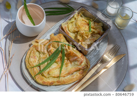 Homemade sweet frying roti (Cannabis Pancake) with Cannabis served with Cannabis tea on ceramic tray. Homemade sweet frying roti (Cannabis Pancake) with Cannabis served with Cannabis tea on ceramic tray. 80646759