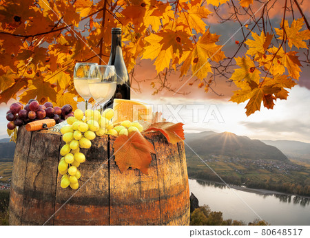 Autumn sunset over Wachau valley with bottle of wine on barrel against Spitz village close to Danube river in Austria 80648517
