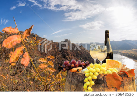 Bottle of wine on barrel against Duernstein castle close to Danube river during autumn in Wachau, Austria 80648520