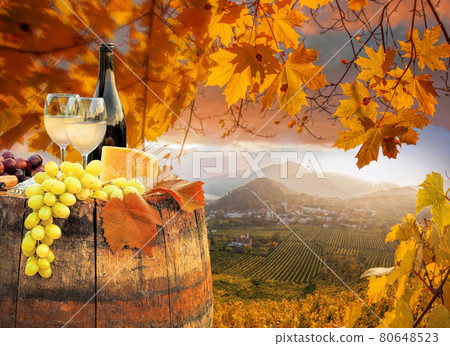 Colorful sunset over Wachau valley with bottle of wine on barrel against Spitz village close to Danube river in Austria Colorful sunset over Wachau valley with bottle of wine on barrel against Spitz village close to Danube river in Austria 80648523