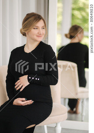 Beautiful pregnant woman sitting on chair at home. Woman waiting for baby 80649810