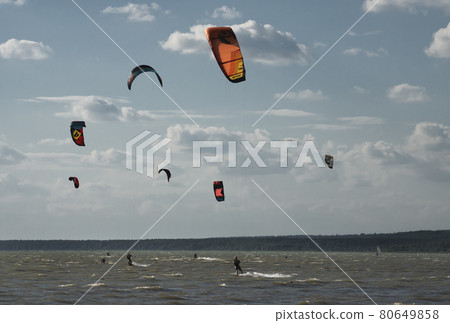 Kitesurfers on the lake ride on crest of a wave. 80649858