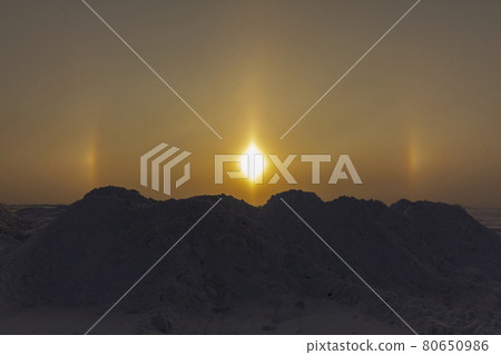 Sunny optical halo effect in the early morning on the background of snow hummocks. The concept of studying the environment. Sunny optical halo effect in the early morning on the background of snow hummocks. The concept of studying the environment. 80650986