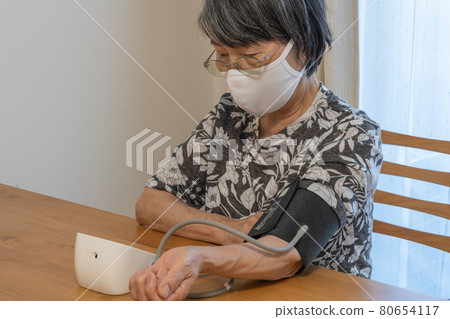 使用 COVID-19 措施面罩測量血壓的老年婦女 80654117