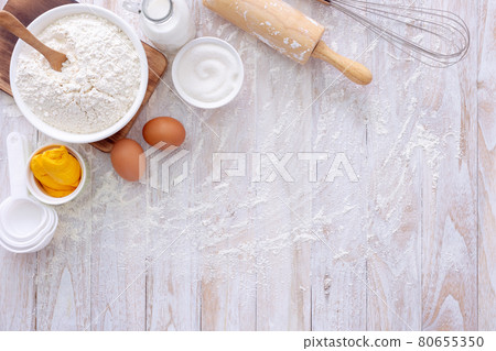 Homemade dough recipe (eggs, flour, milk, sugar) on a wooden table top view. Homemade dough recipe (eggs, flour, milk, sugar) on a wooden table top view. 80655350